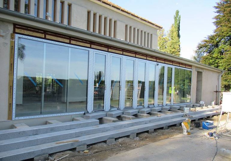 Smuteční síň Soběslav — montáž prosklené stěny a osazování žulových soklových bloků
