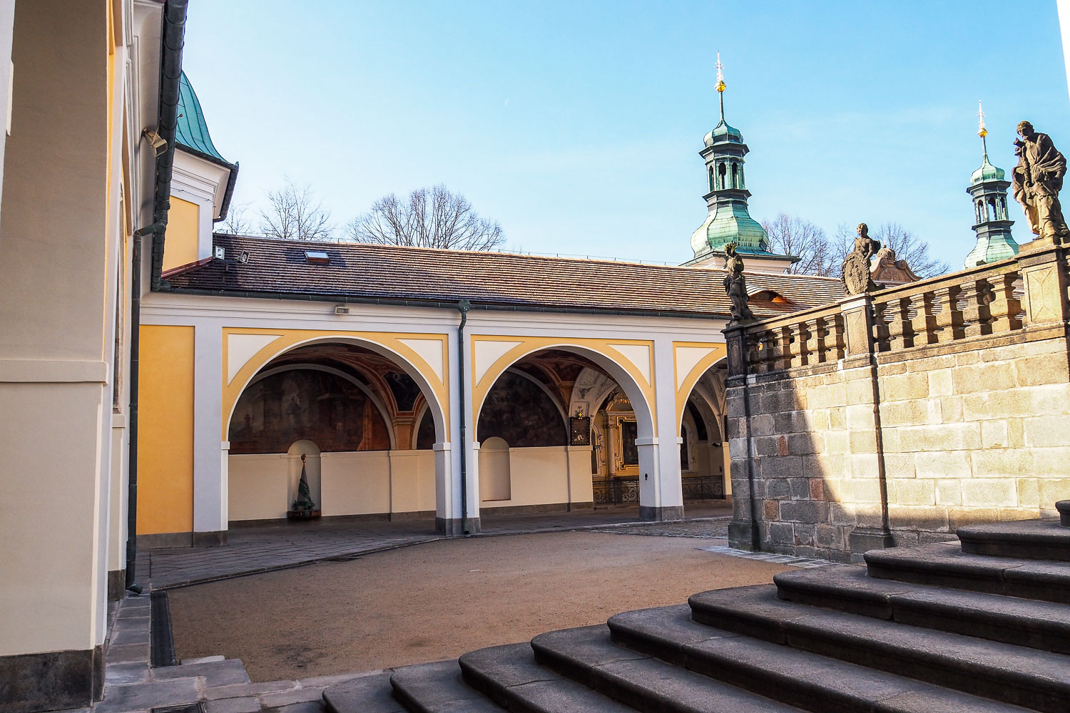 Svatá Hora Příbram — nádvoří s arkádami ambitu a věžemi v pozadí